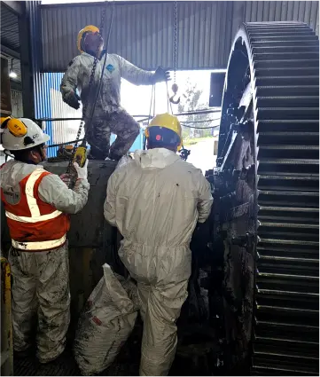 Equipo técnico realizando mantenimiento en molino industrial de gran tamaño